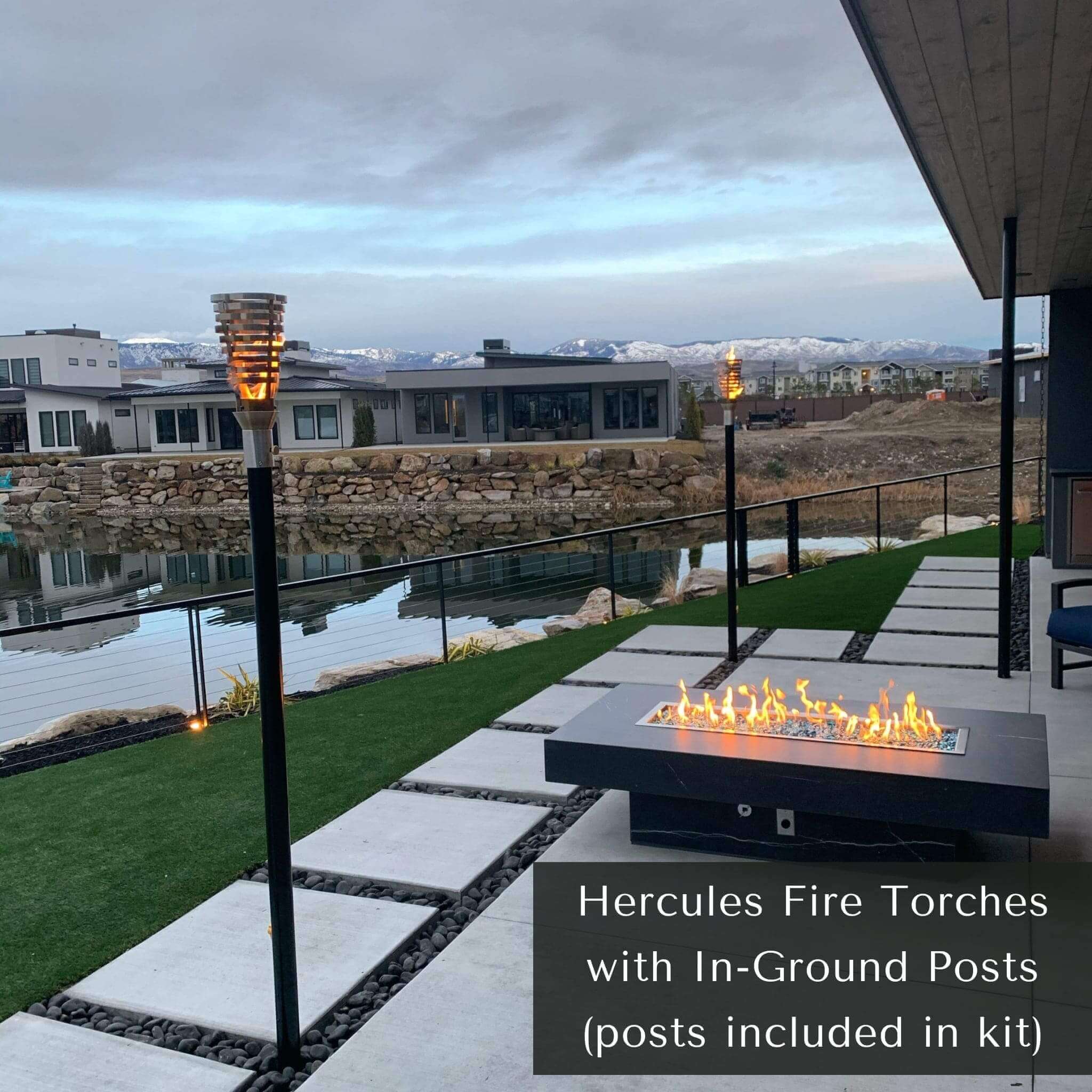 Outdoor patio with fire pit and Hercules fire torches with in-ground posts. The Hercules Fire Torch by The Outdoor Plus is a striking outdoor statement piece, handcrafted from premium 304 stainless steel. Inspired by classical designs and engineered for modern elegance, this torch stands at approximately 14″ tall with an 8″ diameter head. It creates a warm, flickering glow, ideal for lining paths, enhancing pool decks, or accentuating upscale landscaping.