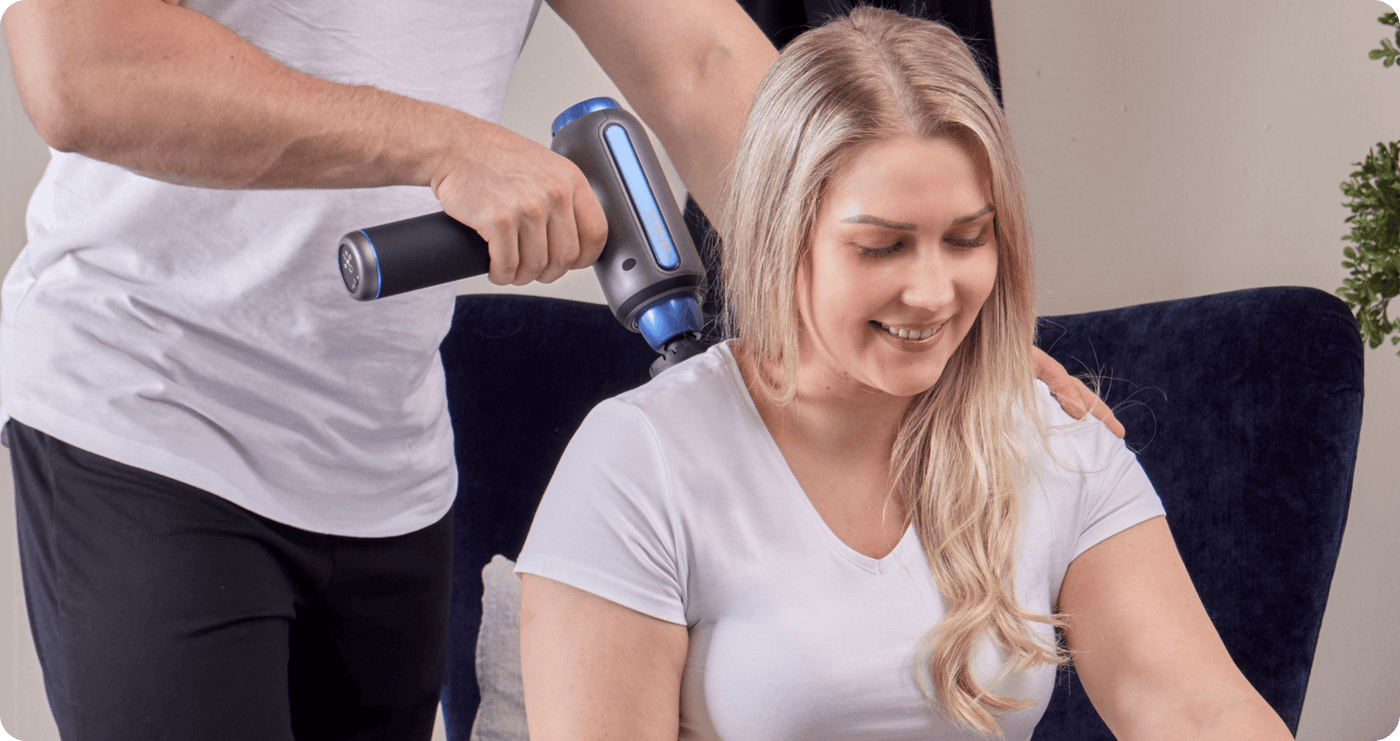Person using a massage gun on another person's arm. The XGUN is a state-of-the-art muscle maintenance device offering adjustable hot and cold therapy to relieve stiffness, soreness, and fatigue. Designed for therapy professionals, athletes, and personal use, its compact and powerful design enhances recovery and performance.