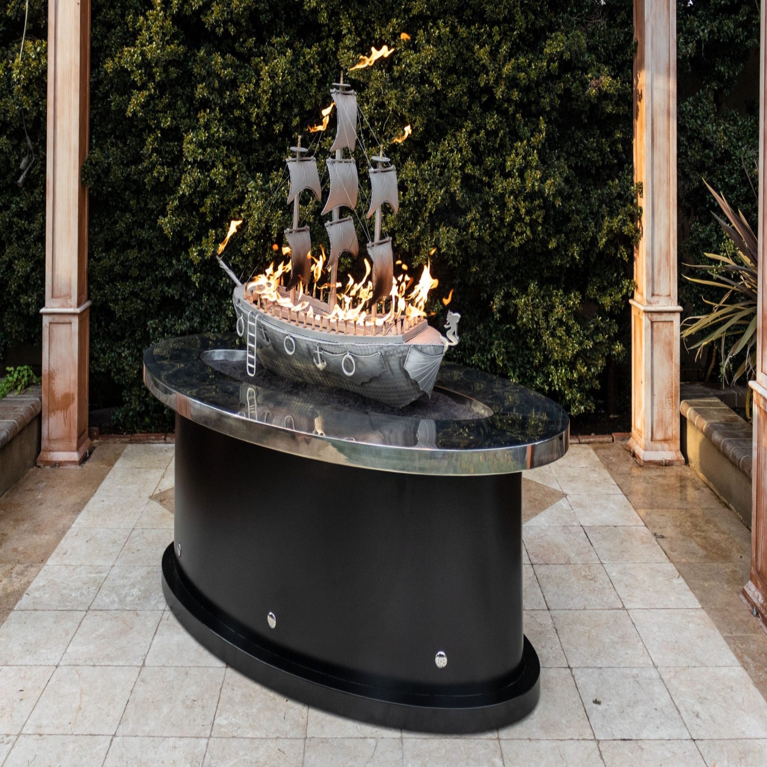 Fire pit with ship design on top in an outdoor setting