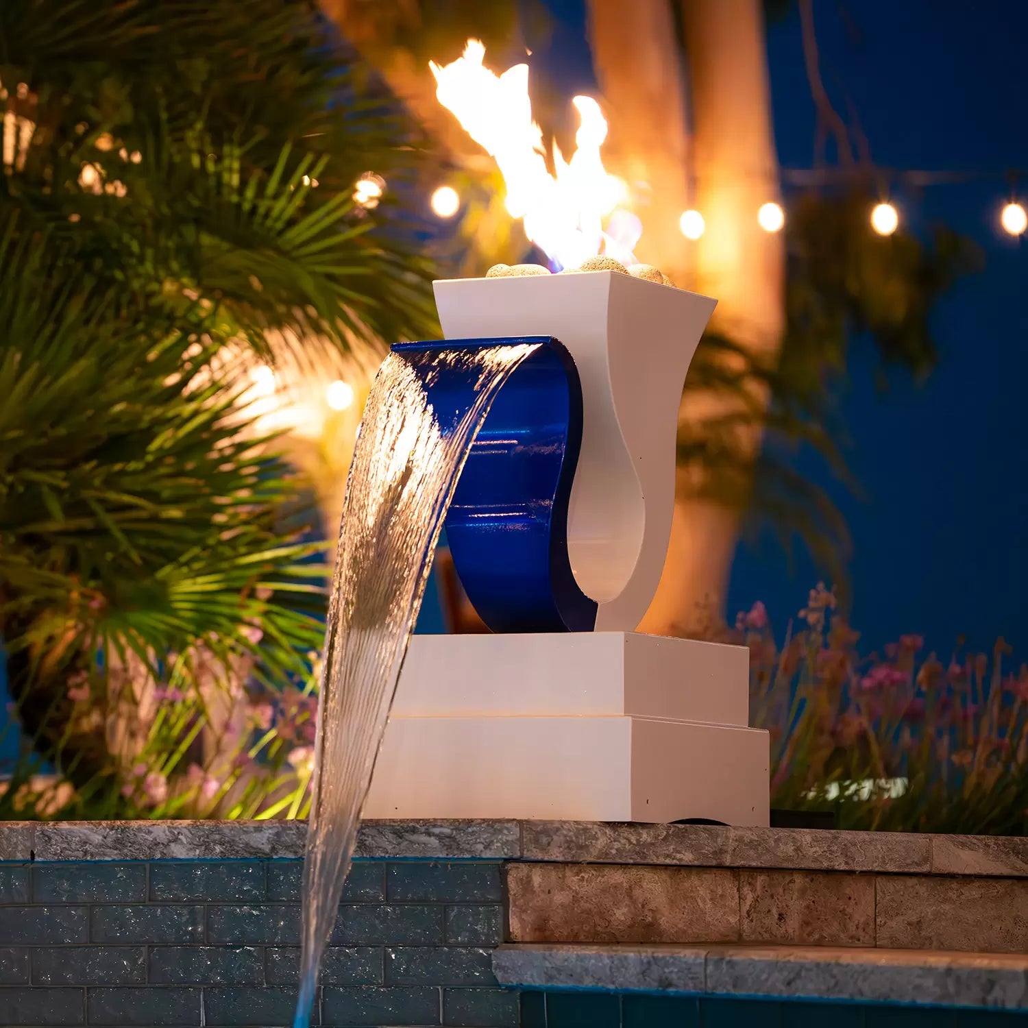 The Designer Series Feature 14 – Fire &amp; Water Scupper is a captivating architectural element that marries the gentle cascade of water with the dynamic glow of fire. This powder-coated metal scupper elevates outdoor spaces—perfect for pool edges, patios, or terraces—by creating an extraordinary visual spectacle spotlighting the harmony of fire pooled above flowing water